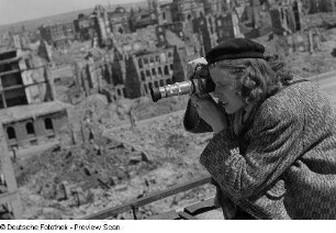 Renate Rössing beim Fotografieren vor Gebäudetrümmern