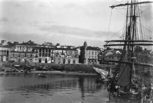 Hafen von Sues : Der Hafen von Sues vom Meer aus. Im Vordergrund ein Segelschiff, im Hintergrund die Hafenpromenade.