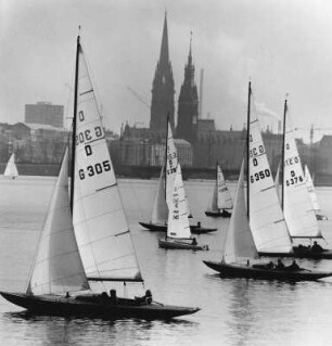Hamburg. Blick von der Außenalster auf die Silhouette der Innenstadt mit den Türmen der Kirche St. Nikolai und des Rathauses. Im Vordergrund Segelboote