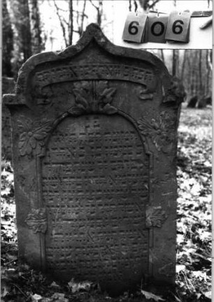 Grabstein 606 (Index: 99753119) Material: Sandstein Zustand: leicht verwittert Maße HxBxT: 113x65x11 cm Beschreibung: eingezog. Kielbogenabschl. , Schriftfeld eingetieft m. eingezog. Rundbogenabschluß Symbolik: Blätter, Schriftband: Grabstein 606