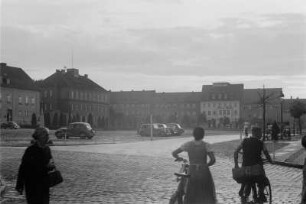 Marktplatz : Blick über einen Marktplatz. Im Vordergrund Passanten.