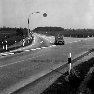 Möllner Landstraße: hinten Mitte Einmündung der Bundesstraße B 404: rechts Pkw: links Fahrradfahrerin auf Radweg: hinten Wiesen und Bäume