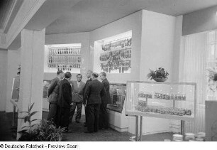 Besucher vor einem Messestand mit Wurstwaren