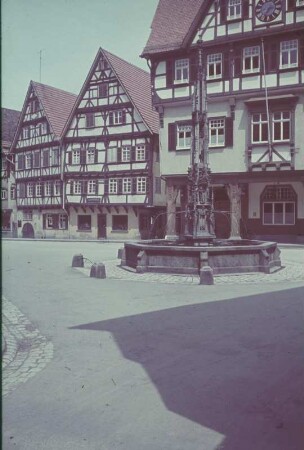 Bad Urach. Markt. Fachwerkhäuser mit Apotheke und Marktbrunnen