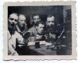 Gruppenbild von Soldaten mit Maschinengewehr in der Mannschaftsunterkunft