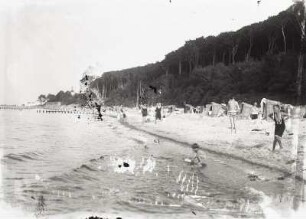 Ostseestrand mit Urlaubern und Strandkörben, dahinter Steilufer mit sog. "Gespensterwald"