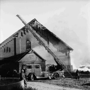 Gut Altfresenburg: Brand des Bullenstalls: Brandruine: Giebelfront mit Anbau: davor Löschfahrzeug mit Drehleiter, Feuerwehrleute: hinten rechts brennender Heuhaufen und Rauchschwaden: 24. August 1971