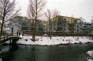 Heiligengeiststraße: Zusammenfluss von Trave und Stadtarm, dahinter Wohnhäuser hinter dem Travewanderweg im Winter