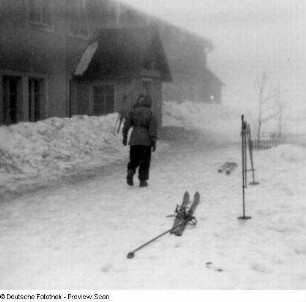 Erzgebirge? Personen und Skier vor einem Haus