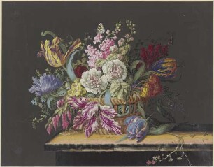 Blumenkorb mit Malven, Levkojen, Primeln, Tulpen und anderen Blumen auf einem Tisch