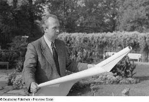 Portrait eines Mannes mit einem Bogen Papier in den Händen
