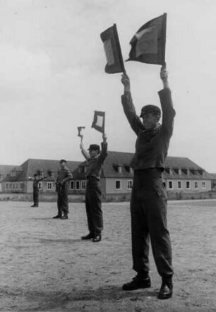Hitlerjugend im Volkswagenwerk. Sie üben im Rahmen ihrer vormilitärischen Ausbildung Flaggenzeichen. Aber warum ?