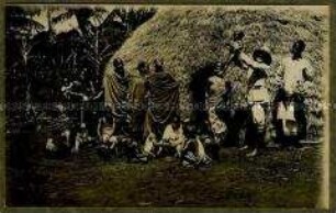 Europäer, ein Kleinkind der Wadschagga haltend, mit Stammesangehörigen