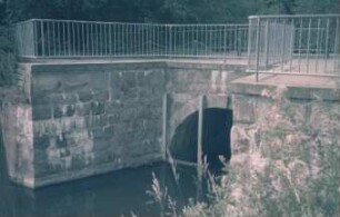 Mühlenredder: Brücke über Abfluss des Schlossgrabens in Aue: Seitenansicht von Süden: vor Brückenbogen senkrechte Eisenträger: oben Geländer