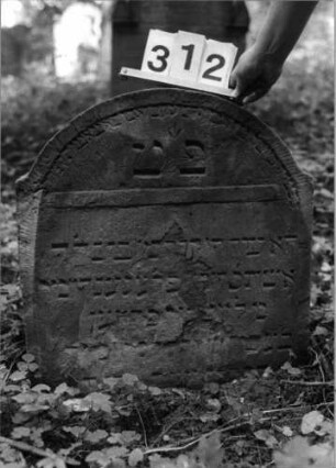 Grabstein 312 (Index: 99803480) Material: Sandstein Zustand: verwitt/eingesunk/Textverlust Maße HxBxT: 60x56x10 cm Beschreibung: Stele mit Karniesbogen und Giebelfeld: Grabstein 312