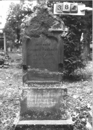 Grabstein 384 (Index: 99787590) Material: Sandstein Zustand: zerbrochen und repariert, sehr stark verwittert am Giebel Maße HxBxT: 159x52x14 cm: Grabstein 384