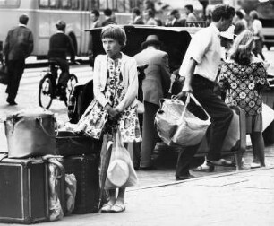 Am Hamburger Hauptbahnhof. Die Familie verreist. Das Mädchen muss auf das Gepäck achten