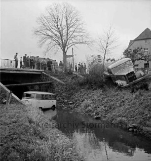 Verkehrsunfall: Kalkgraben: bei Einmündung in Hamburger Chaussee / B 75 und Brücke über Heilsau: Zementlastwagen mit Anhänger schräg auf Uferböschung: Wäscherei-Lieferwagen in Heilsau: rechts oben Eckhaus Gasthof "Kalkgraben": links oben an Brückengeländer Zuschauer, Baum, Wegweiser, im Hintergrund Haus: im Vordergrund links Wiese, Zaun