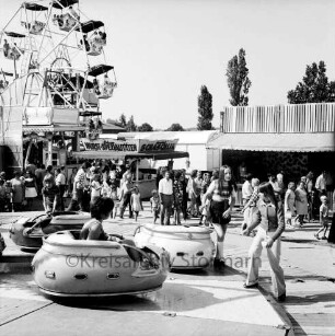 Schützenfest: Veranstalter Bürgerschützengilde von 1627 e.V. Bad Oldesloe: Volksfestplatz bei Schützenhalle, Sehmsdorfer Straße: vorne Karussell, Kinder beim Besteigen der Gondeln: Riesenrad, Imbissstand, Stand zum Pfeilewerfen: Besucher mit Kindern, 29. Juli 1973