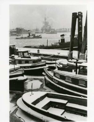 Hamburg. Hafen. Winter. Schlepper liegen im teilweise vereisten Hafenbecken vor Anker.