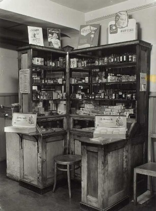 Frisiersalon Kliem. Vitrinenschrank mit Haarkosmetika und Drogerieartikeln