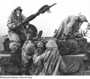 Deutschland . Nationale Volksarmee - Landstreitkräfte. Übung des Medizinischen Dienstes. Soldaten in Schutzbekleidung bei der Übergabe einer Trage aus einem Gefechtsfahrzeug