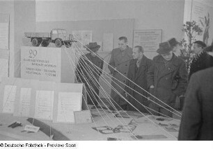 Ausstellungsbesucher vor dem Exponat "29 Verbesserungsvorschläge am Horch-Lastkraftwagen"