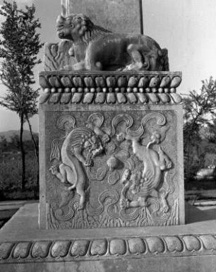 Ming-Gräber (Kaisergräber) bei Peking (ab 1490). Tor. Löwe am Fuße eines Pfeilers (vielleicht ein Torwächter) auf einem Sockel mit Reliefdarstellung zweier einander umschleichender Löwen