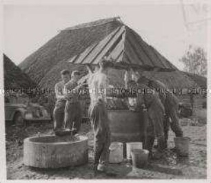 Wehrmachtssoldaten, Soldaten in Rußland, Am Brunnen eines russischen Gehöftes ist Wasserholen am Morgen eine dringliche Angelegenheit.
