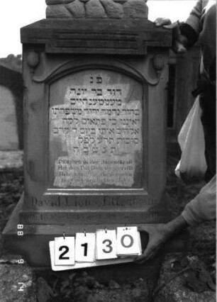 Grabstein 2130 (Index: 100097088) Maße HxBxT: 240x52x42 cm Symbolik: Baumstamm Besonderheit: kulturhistorisch wertvoll / künstl.-formale und hist.-wiss. Gründe (verunglücktes Kind, Inschrift); - Kindergrab: Grabstein 2130 (Detailaufnahme)