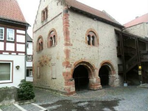 Stadtbild-Romanisches Steinhaus (1187-Vogtei 1984-renoviert)- Ansicht querab über Hofseite mit renovierten Biforien im Obergeschoß und Treppengiebel sowie Arkaden der Erdgeschoßhalle