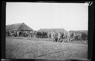 Rossienie (=Raseiniai, Litauen): Rast vor reetgedeckten Gebäuden ("Einfall in Kurland: Rast bei Rossjenie. 27.4.1915")