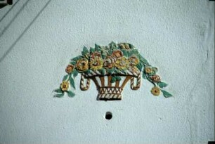 Detail an einer Hauswand, farbige Keramik (Blumenkorb)