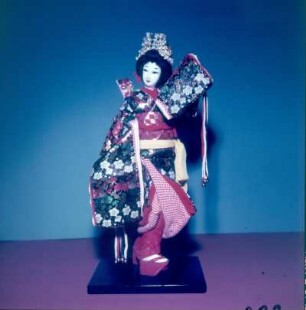 Japan. Japanische Sakura-Ningyo (Kirschblüten-Puppe), japanische Gliederpuppe im bestickten Seidenkleid auf einem kleinen Podest stehend