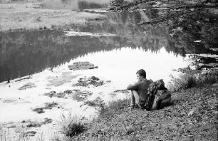 Sitzender Wanderer am Ufer des nonnenmattweihers bei Neuenweg