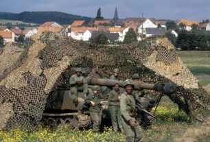 US-Soldaten mit einem Panzer unter einem Tarnnetz während eines NATO-Manövers in Hessen
