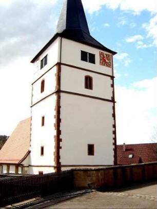 Kirchturm von Ostsüdosten (im Kern Romanisch - Schießscharten neuzeitlich zu Fenstern erweitert oder übertüncht) - Glockenstube im 17 Jh erneuert - über Resten der Kirchhofmauer