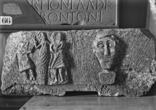 Relief mit Kopf und drei Figuren