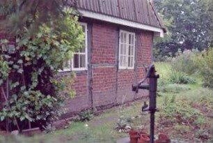 Klein Hansdorf: Am Wischhof (14): traufständige Fachwerkkate: Giebelseite Wohntrakt, an Giebel Verkleidung: Garten: im Vordergrund Wasserpumpe
