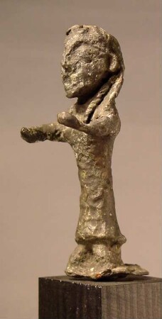 Primitive Statuette einer Frau. "Rohes, sehr stark oxydiertes Figürchen mit großem, plumpen Kopf und vorgestreckten Armen"