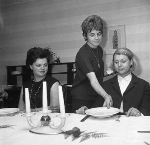 Servierfachschule. Angehende Kellnerin erlernt das Reichen eines Tellers von der rechten Seite des Gastes