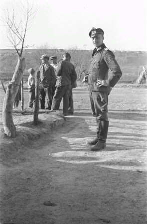 Zweiter Weltkrieg. Zur Einquartierung. Sowjetunion. Angehöriger der deutschen Wehrmacht mit Einheimischen auf einem Dorfplatz