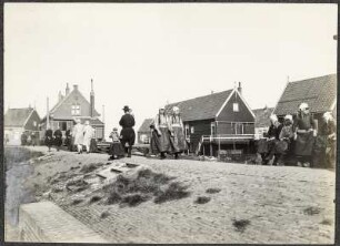 Niederlande, Marken. Deich mit Passanten und Wohnhäusern