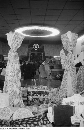 Besucher vor einem Messestand mit Stoffen in der Messehalle des Ausstellungslandes Bulgarien