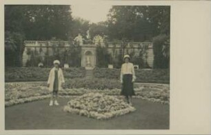 Fotografie einer stehenden Dame und eines Mädchens