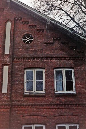 Schönningstedt: Dorfstraße 17: Bauernhaus aus Backstein: Giebelseite Wohntrakt, Teilansicht rechts: Sprossenfenster, Rundfenster: Lisene mit Putzflächen, Gesims