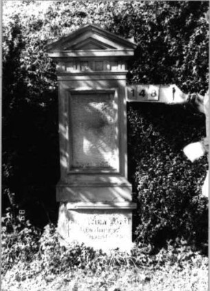 Grabstein 148 (Index: 99792748) Material: Sandstein Zustand: verwitt/Textverl/Plat. fehlt/Sock. beschäd Maße HxBxT: 178x60x25 cm Beschreibung: Stele, profilierter Sockel, Giebel, rechteckiges Schriftfeld eingetieft Symbolik: Felderfries: Grabstein 148