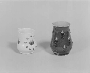 Henkeltöpchen mit flammendem Herz und Blüten und Vase mit flammenden Herzen : Henkeltöpchen mit flammendem Herz und Blüten und Vase mit flammenden Herzen. Keramik, glasiert, plastische Auflagen (M. 20. Jh.; wohl K. Feuerriegel). Museum im Schloß Frohburg