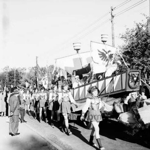 Karpfenfest: Umzug: Festwagen aus Lübeck: Hansekogge mit Stadtwappen, begleitet von Kriegerinnen in Harnisch und Helm: links Zuschauer: Strommasten, 11. Oktober 1959