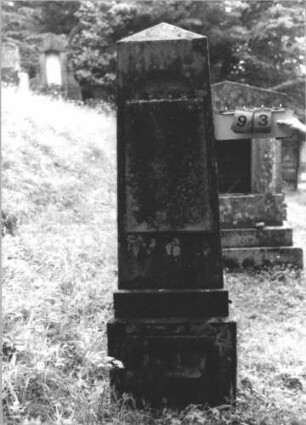 Grabstein 93 (Index: 99800129) Material: Sandstein ? Maße HxBxT: 89x52x26 cm Beschreibung: obeliskenartige Stele, eingelassene Ersatzplatte unbeschriftet, getreppter Sockel: Grabstein 93